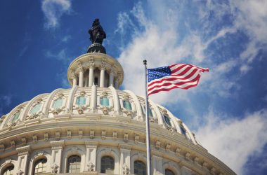 US capitol with flag and blue sky