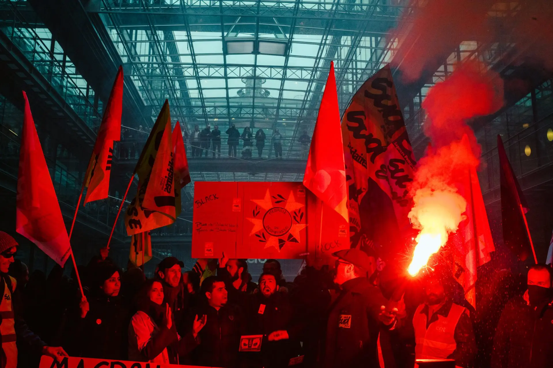 Fachada de oficinas de un gran gestor de fondos en París con bengalas encendidas y manifestantes en la calle