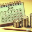 Coins stacked next to the May calender