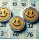 three coins with smiley faces