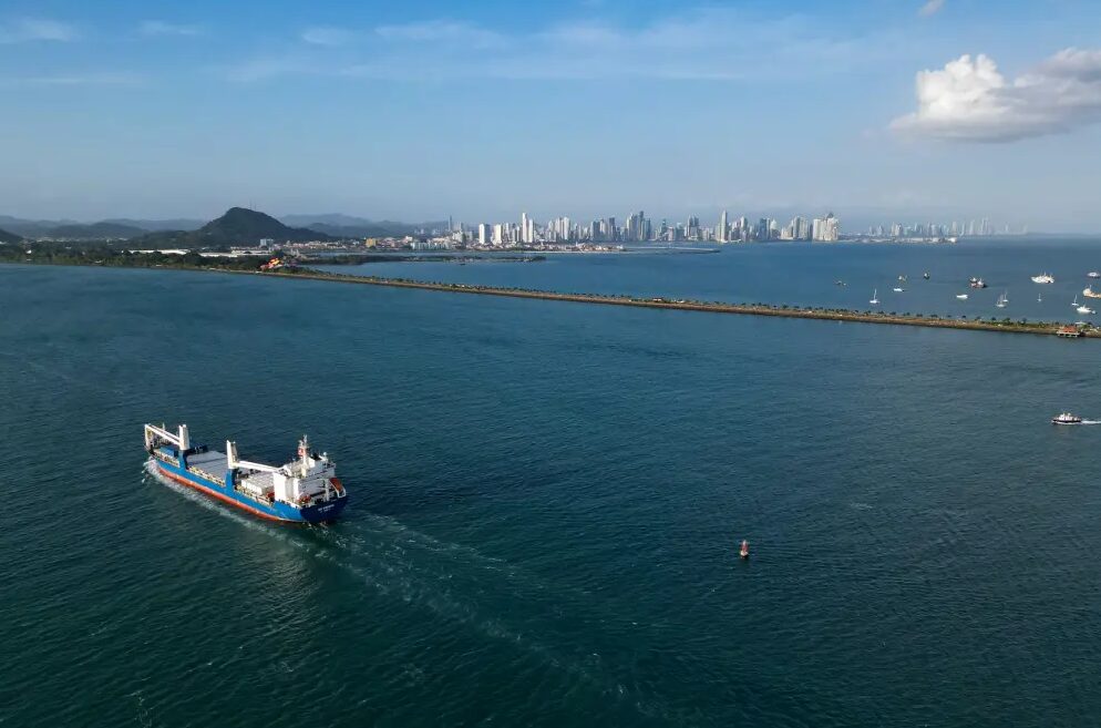 Aerial view of shipping vessel traversing blue waters near Panama Canal