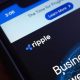 Ripple logo displayed on smartphone with financial interface