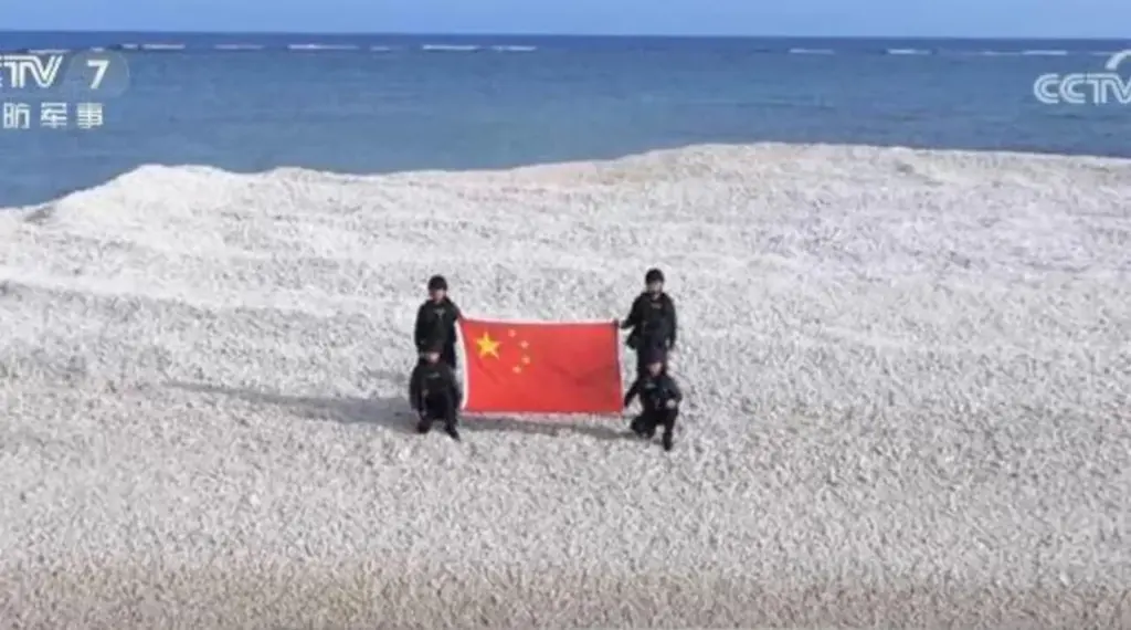 Chinese officers holding their flag on a disputed sandbank in the South China Sea