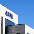 ASML logo on white office building against blue sky