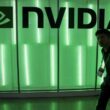 Nvidia logo illuminated in green light with person walking past