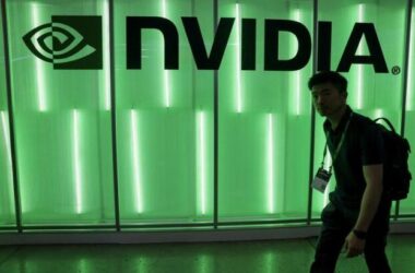 Nvidia logo illuminated in green light with person walking past