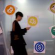 A man walks past a cryptocurrency exchange store after Bitcoin soars above $100,000