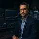 Professional financial analyst at modern trading desk with multiple screens showing Bitcoin charts and US government wallet addresse