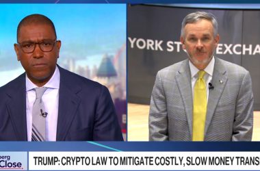 Bloomberg interview split screen showing host and Western Union CEO Devin McGranahan discussing crypto law to mitigate costly, slow money transfers