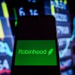 Robinhood logo on phone with charts background