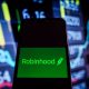 Robinhood logo on phone with charts background