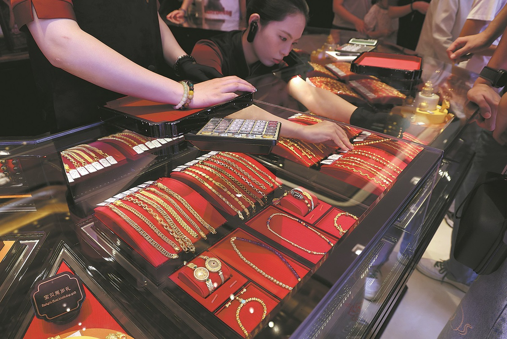 Image 2: Salesperson arranging gold jewelry